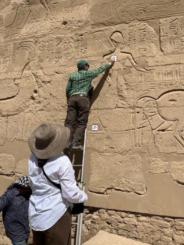 Cooper Phillips (’22) attaches a sensor to Ramesses II’s chest while working at the Great Hypostyle Hall at Karnak.